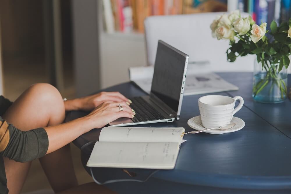 Girl typing on laptop for text to voice conversion